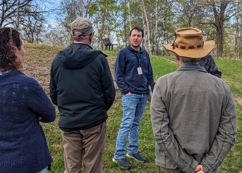 People listen to naturalist talk about savanna