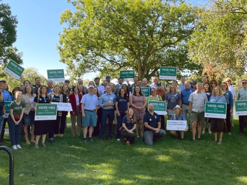 large group of people holding Vote Yes signs