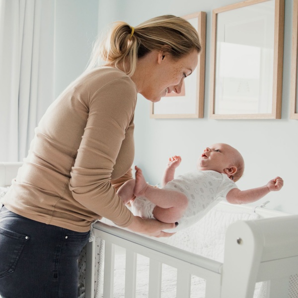 Mom picks up baby from crib