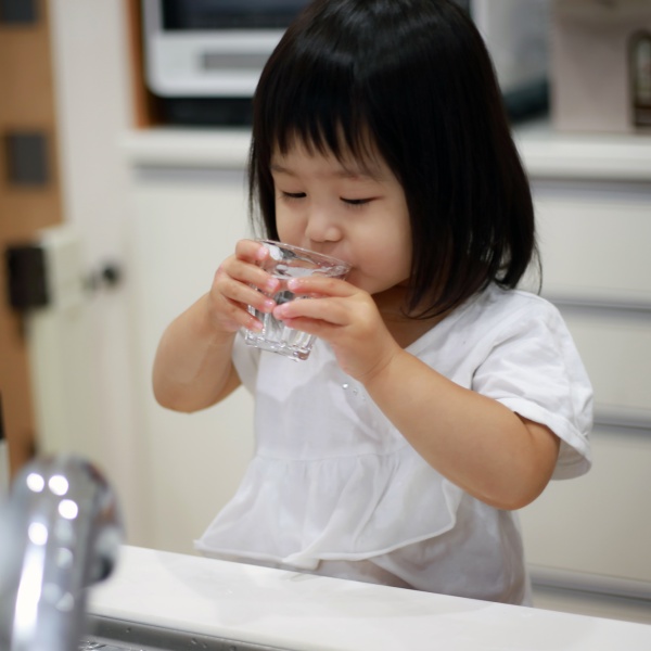 Child drinks a glass of water